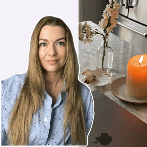 een vrouw aan een tafel met een kaars en bloemen