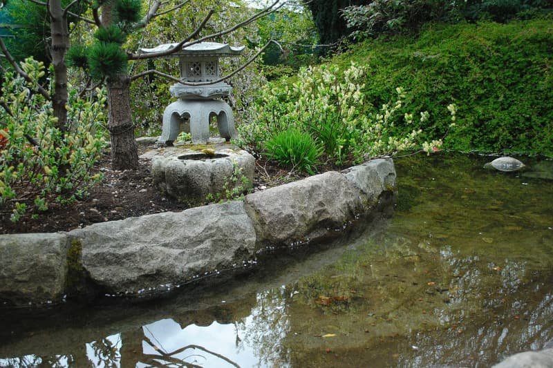 Een stenen zonnewijzer in een serene tuin, symbool voor de heldere, strategische richting die Adverdream biedt aan ondernemers.
