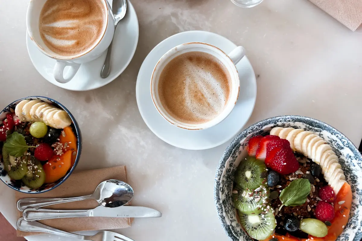 Een warm welkom en een goed begin. Een uitnodigende ontbijttafel met twee koppen koffie en acai bowls, symbool voor de warme en persoonlijke start van een samenwerking met Adverdream.